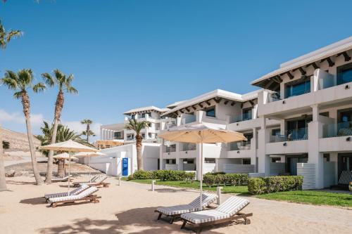 a building with benches and umbrellas in front of it at Zel Fuerteventura in Costa Calma