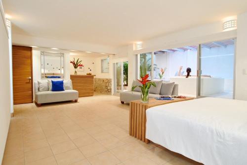 a bedroom with a large bed and a living room at Hotel Casa de sal in Acapulco