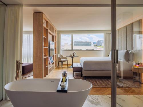 a hotel room with a tub and a bedroom at ME by Meliá Lisbon in Lisbon