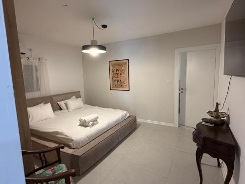 a small bedroom with a bed and a table at סוויטות שריתא in Shomera