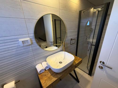 a bathroom with a sink and a mirror at סוויטות שריתא in Shomera