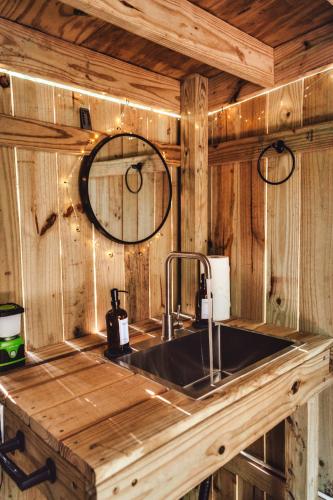 a sink in a wooden kitchen with a mirror at Charming A-Frame Couples Retreat Cozy and Private in Rockbridge