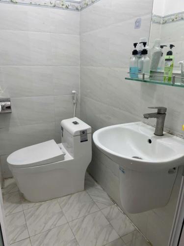 a white bathroom with a toilet and a sink at Lakshmi 2BR House Da Lat in Ấp Phước Thánh