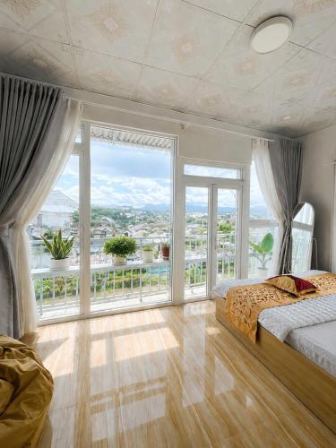 a bedroom with a bed and a large window at Lakshmi 2BR House Da Lat in Ấp Phước Thánh