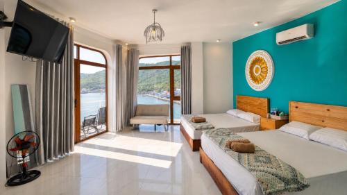 a bedroom with two beds and a blue wall at Coco Bay Hon Son in Lai Sơn