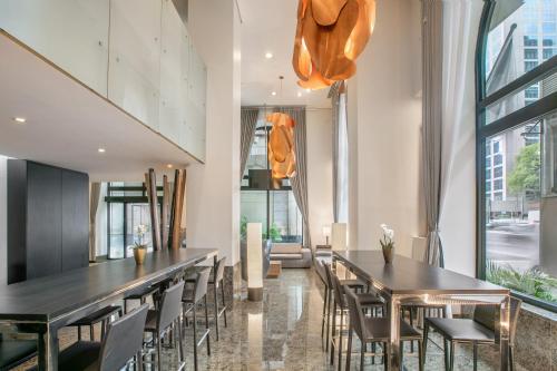 a dining room with tables and chairs and windows at Meliá Paulista in São Paulo