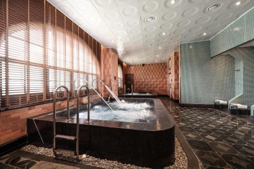 a bathroom with a large tub with water at Silk Path Dong Trieu Golf Course & Villas in Trại Sưu