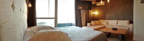 a hotel room with a bed and a couch at Scorpios Sea Side Hotel in Piraeus