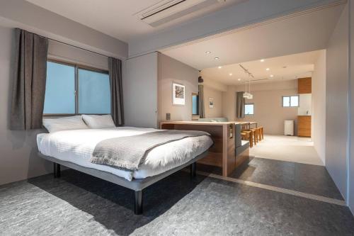 a bedroom with a bed and a kitchen and a bathroom at 9STAY Kikukawa in Tokyo