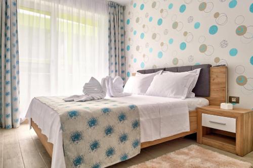 a bedroom with a bed with a blue and white bedspread at Apartament Alezzi Beach in Năvodari