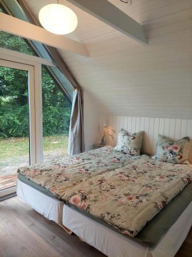 a bed in a room with a large window at Modern Oasis Surrounded By Nature in Ry