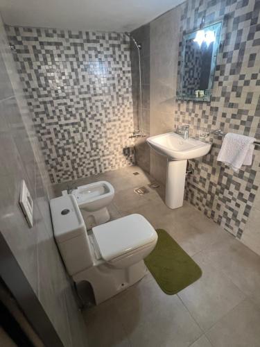 a bathroom with a toilet and a sink at Countryside Guesthouse in Kafr Nabrakh