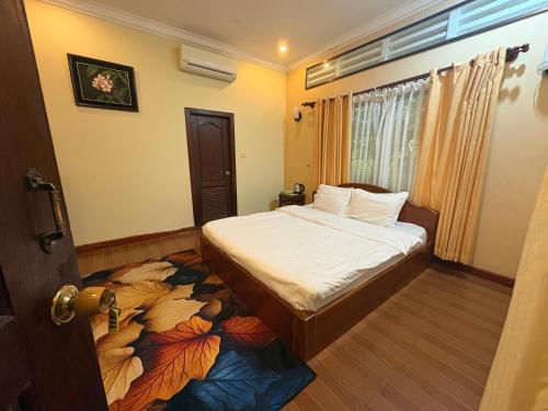 a bedroom with a bed with a flower carpet at Kep Ocean Inn in Kep