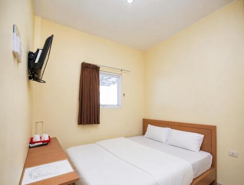 a hotel room with a bed and a window at Ava Guesthouse Lampung in Tanjungkarang