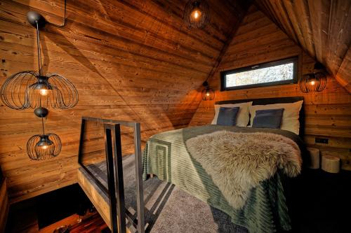 a bedroom with a bed in a wooden cabin at Glamping Babákov in Včelákov