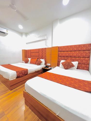 two beds in a room with wooden floors at Hotel Grand Royal Sandhu in Amritsar