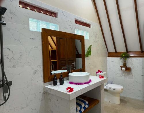 a bathroom with a sink and a toilet at Lucy's Garden Hotel in Gili Islands