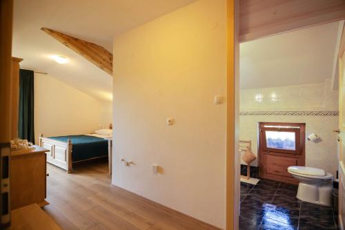 a bathroom with a toilet and a bed in a room at Green Escape garni hotel in Postojna