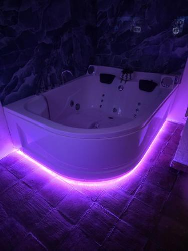 a white bath tub with purple lights in a room at La Dimora del Grifo in Mascalucia