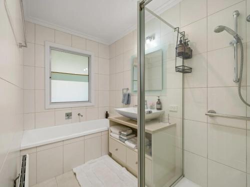 a white bathroom with a sink and a shower at Via Bella Vista in Wangaratta