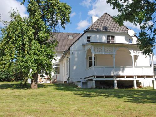 a white house with a tree in the yard at Gutshaus Glowitz in Glowitz