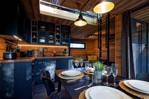 a dining room with a table with wine glasses at Glamping Babákov in Včelákov
