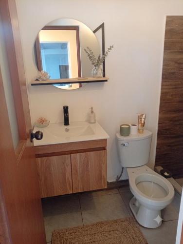 a bathroom with a toilet and a sink and a mirror at Anta lodge in Huaraz