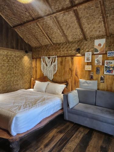 a bedroom with a large bed and a couch at Lombok Rice Terracce Glamping in Tetebatu