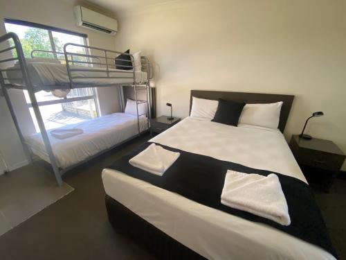 a bedroom with two bunk beds and a window at Dooley's Tavern & Motel Springsure in Springsure