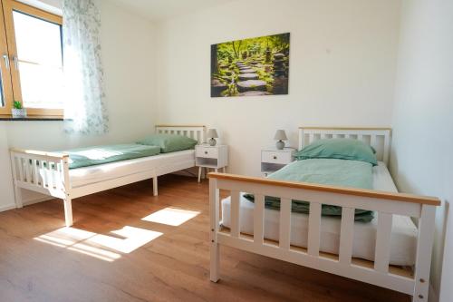 a bedroom with two beds and a window at Ferienwohnung auf dem Stroblhof in Polling