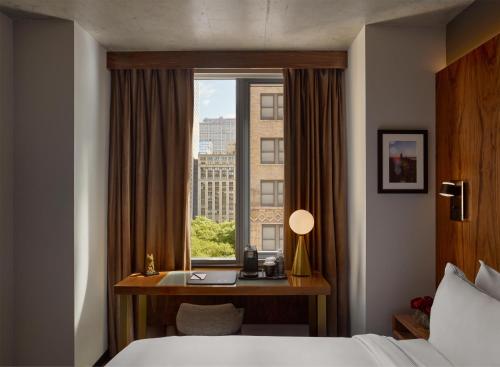 a hotel room with a desk and a window at Grayson Hotel in New York