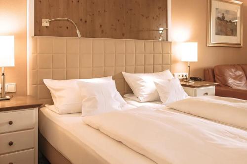 a bed with white sheets and pillows in a room at Aparthotel Alter Weißbräu in Bad Birnbach