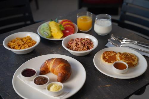 a table topped with plates of breakfast foods and drinks at Premium Stay Prishtina in Prishtinë