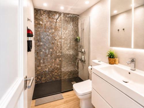 a bathroom with a shower and a toilet and a sink at Solymar Premium Apartment in Playa del Ingles
