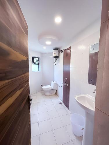 a bathroom with a toilet and a sink at Hotel Royal Green - Green Park Metro in New Delhi
