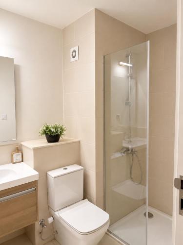a bathroom with a toilet and a glass shower at Marassi- Faya Residence in El Alamein
