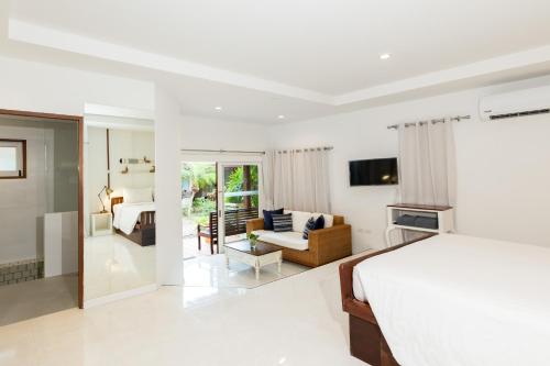a bedroom with a bed and a living room at Malibu Beach Resort Samui in Chaweng