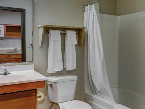 a bathroom with a toilet and a sink and a shower at WoodSpring Suites Council Bluffs in Council Bluffs