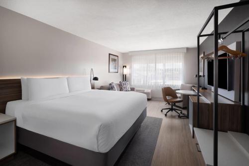 a hotel room with a large bed and a desk at Wyndham Garden Manassas in Manassas