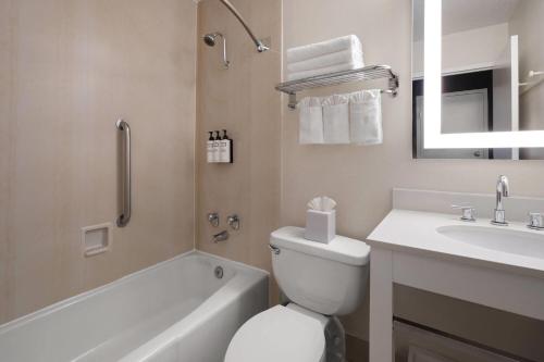 a white bathroom with a toilet and a sink at Wyndham Garden Manassas in Manassas