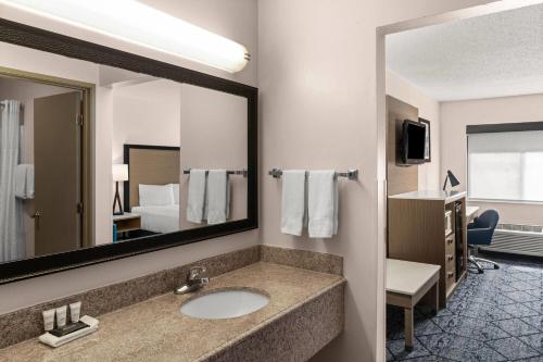 a bathroom with a sink and a mirror at Baymont by Wyndham Columbia, MO in Columbia