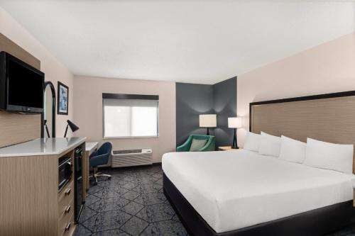 a hotel room with a bed and a desk at Baymont by Wyndham Columbia, MO in Columbia