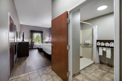 a hotel room with a bed and a bathroom at La Quinta Inn & Suites by Wyndham Louisville East in Louisville