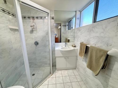 a bathroom with a shower and a sink at Ocean Shores Apartment 13 in South West Rocks