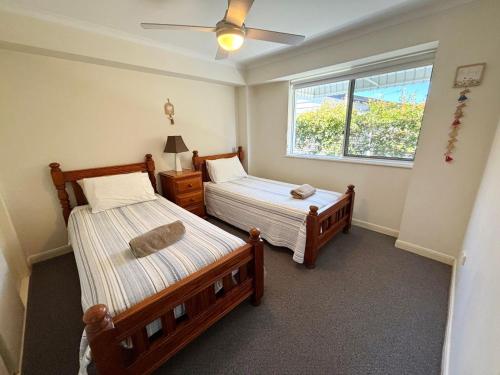 a bedroom with two beds and a window at Ocean Shores Apartment 13 in South West Rocks