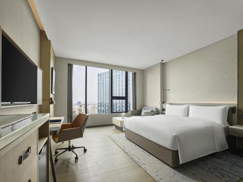a hotel room with a large bed and a desk at DoubleTree by Hilton Chengdu Riverside in Chengdu