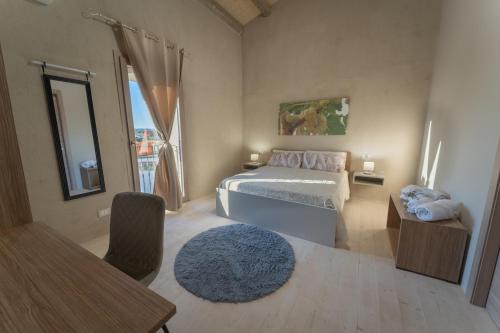 a bedroom with a bed and a table and a window at U Minnulitu in Caltagirone