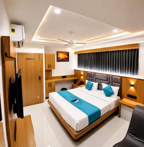 a bedroom with a large bed and a desk at Hotel Sunrise in Ahmedabad
