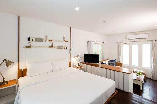 a bedroom with a white bed and a desk at Malibu Beach Resort Samui in Chaweng