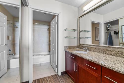 a bathroom with a sink and a mirror at MainStay Suites Appleton Airport - Fox River Mall Area in Appleton